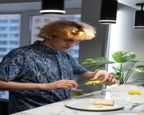 man preparing a simple meal at a kitchen island in a Budapest apartment