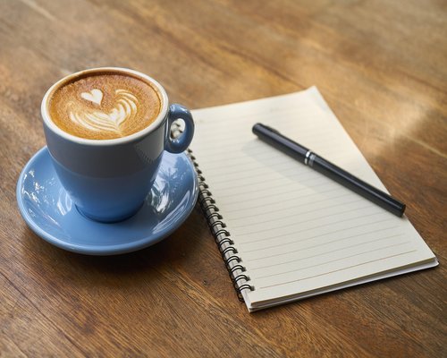 notebook and coffee cup on a cafe table in Budapest